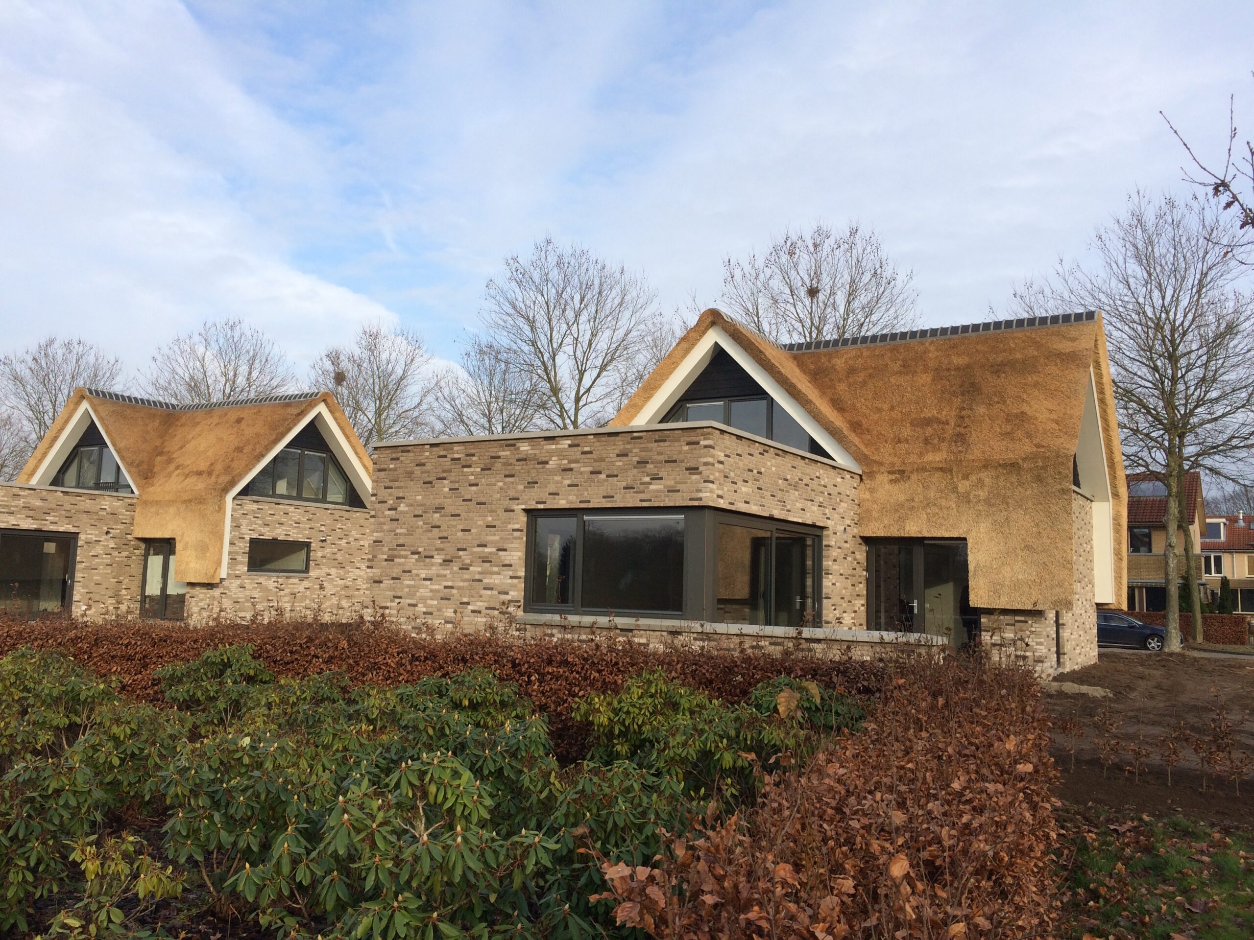Moderne villa met grote raampartijen en natuurlijke materialen.