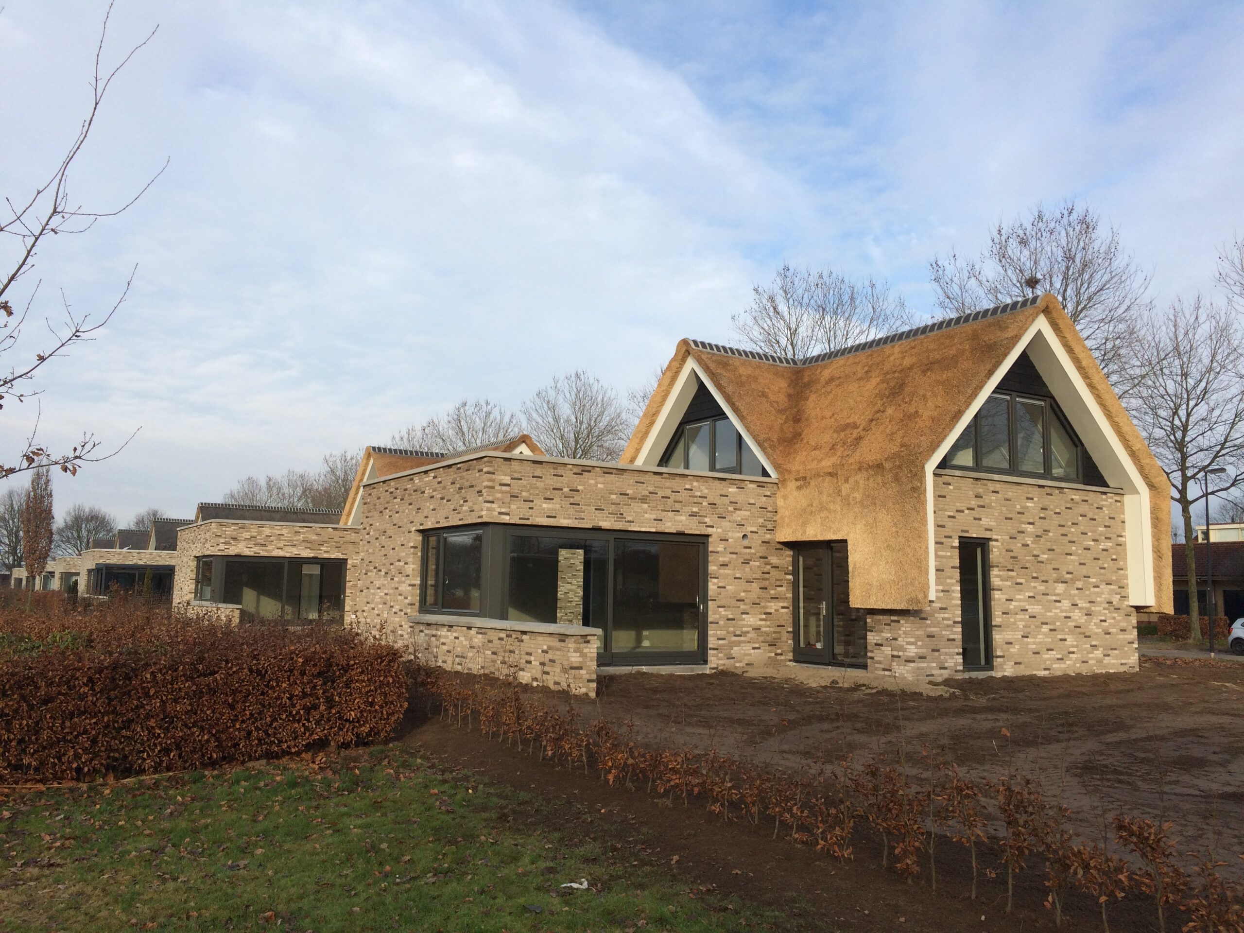 Moderne villa met grote raampartijen en natuurlijke materialen.