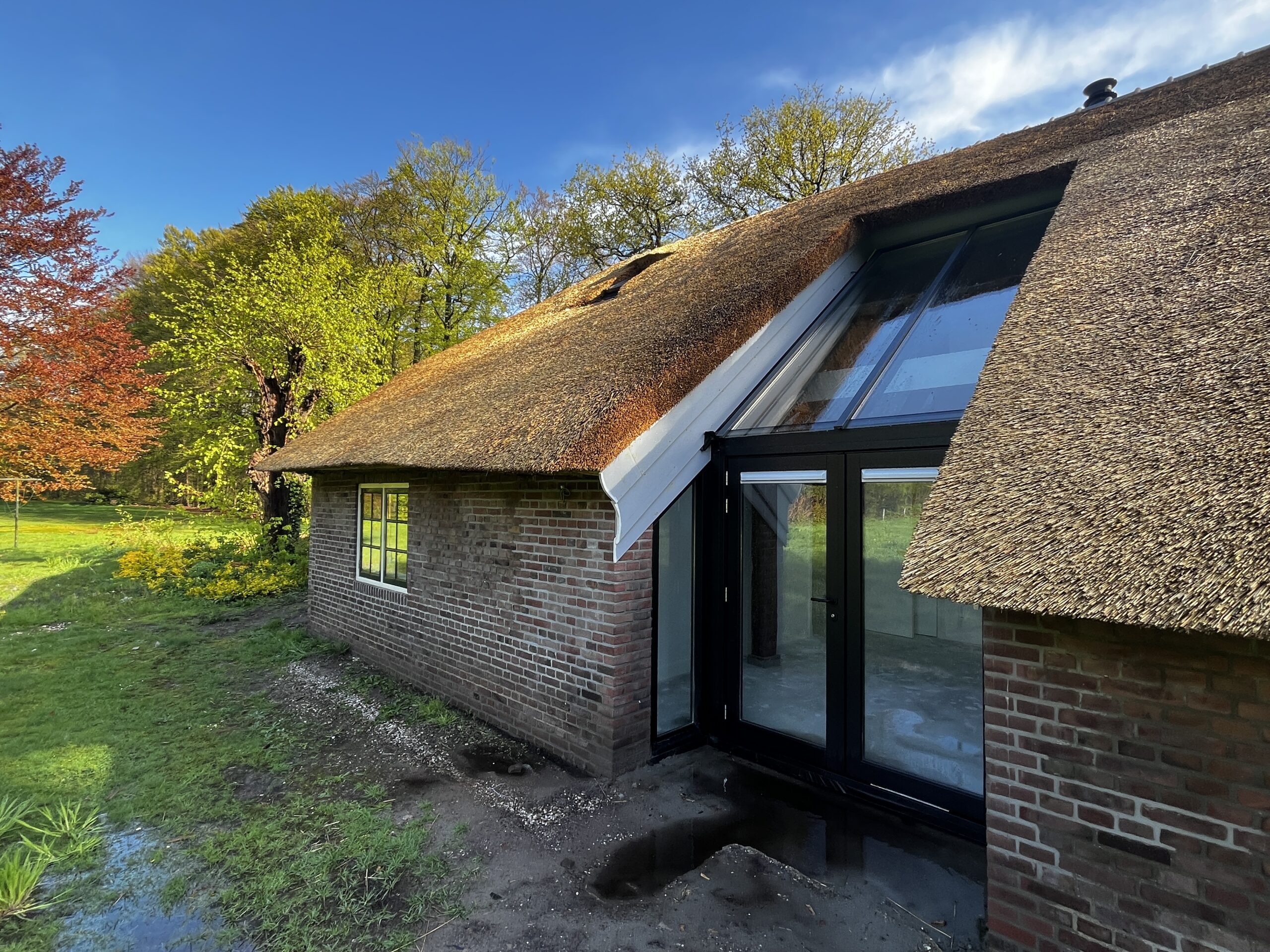 Centrale daklichtconstructie met eiken lamellen in de boerderij.