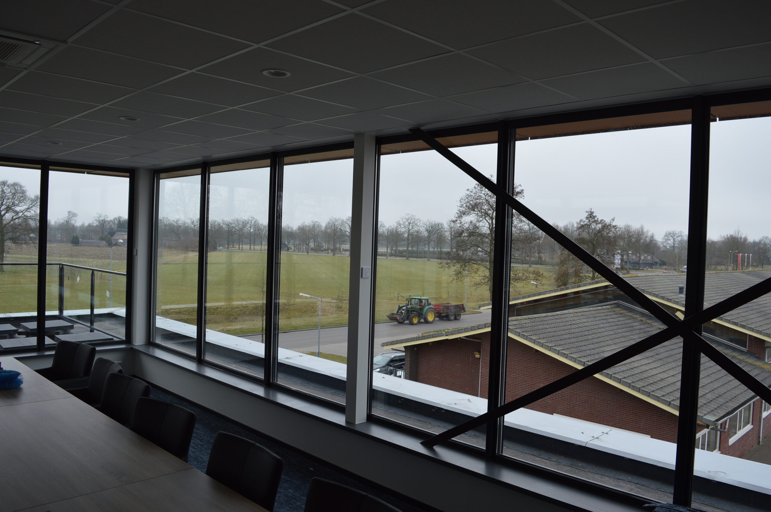 Kantoorruimte met grote aluminium puien en uitzicht over de omgeving.