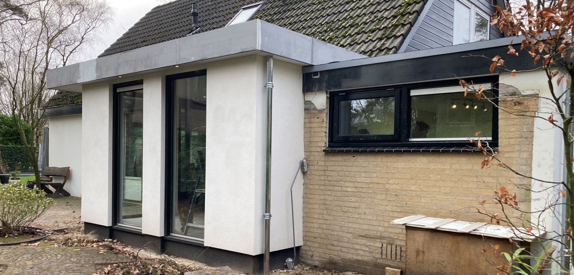 Moderne uitbouw aan een woning in Vaassen met grote aluminium puien.