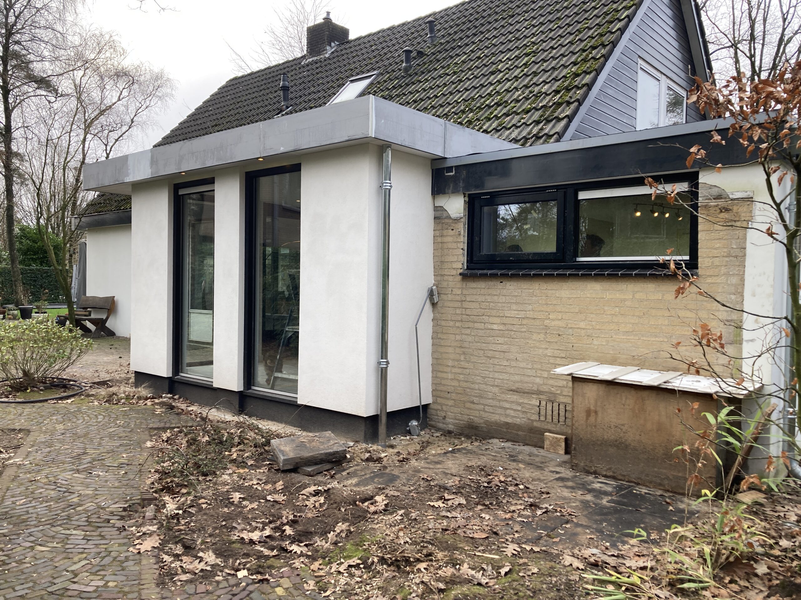 Moderne uitbouw aan een woning in Vaassen met grote aluminium puien.