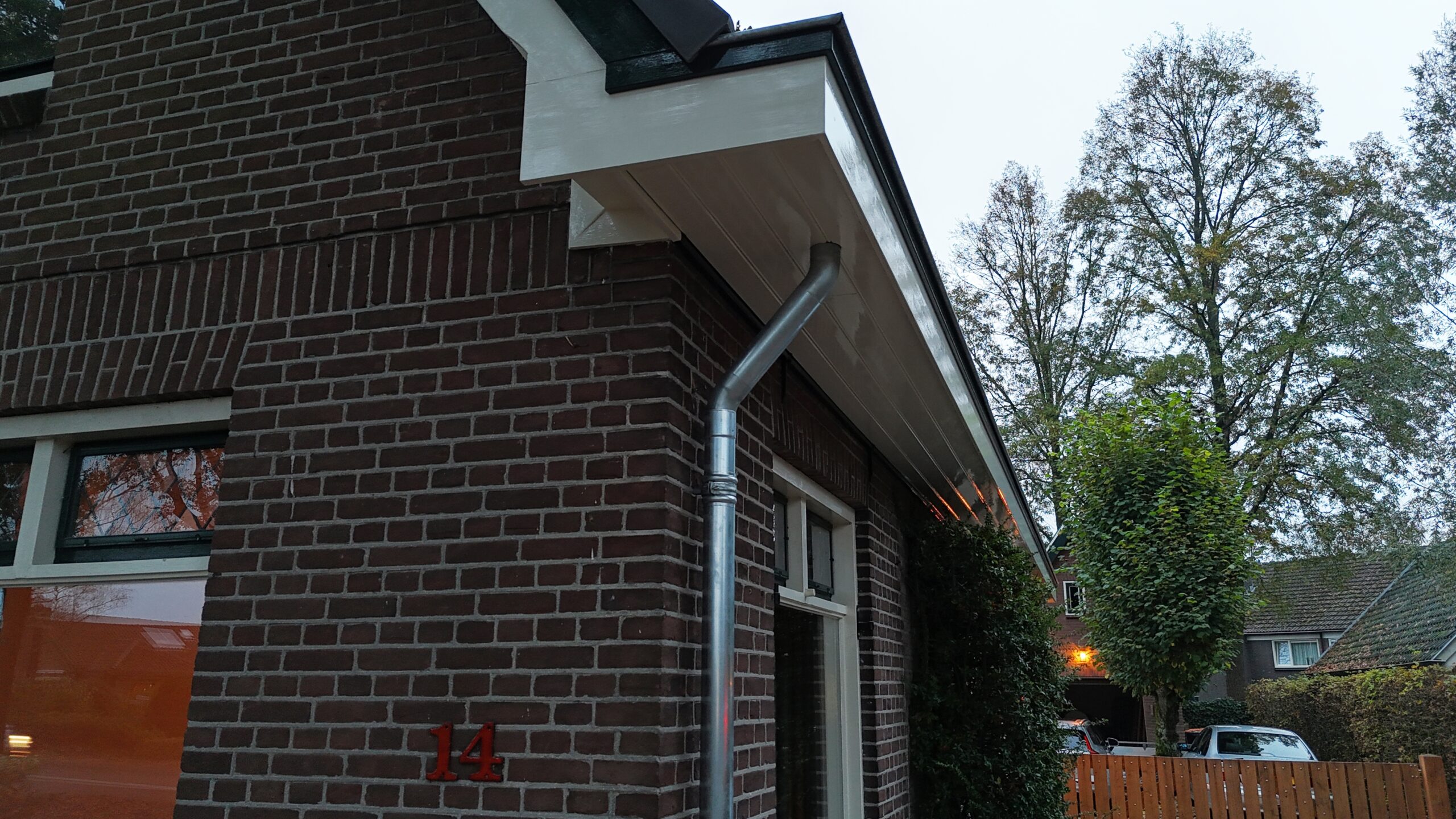 Vernieuwde goten en dakafwerking na een dakrenovatie.