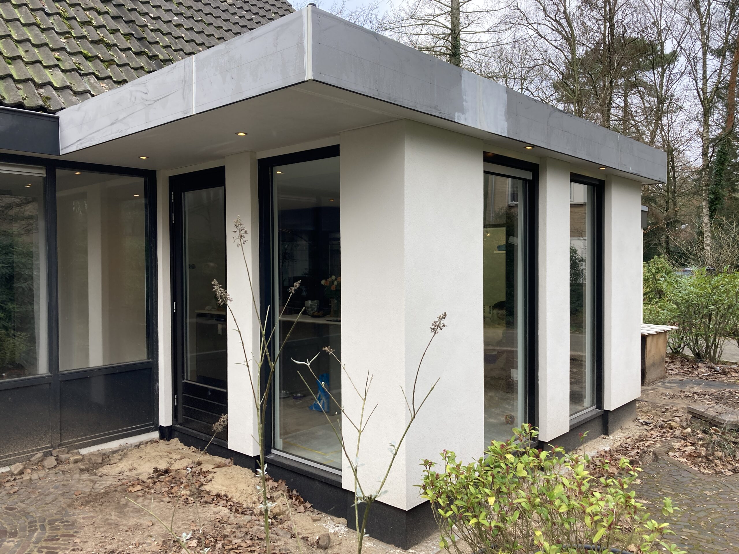 Moderne uitbouw aan een woning in Vaassen met grote aluminium puien.