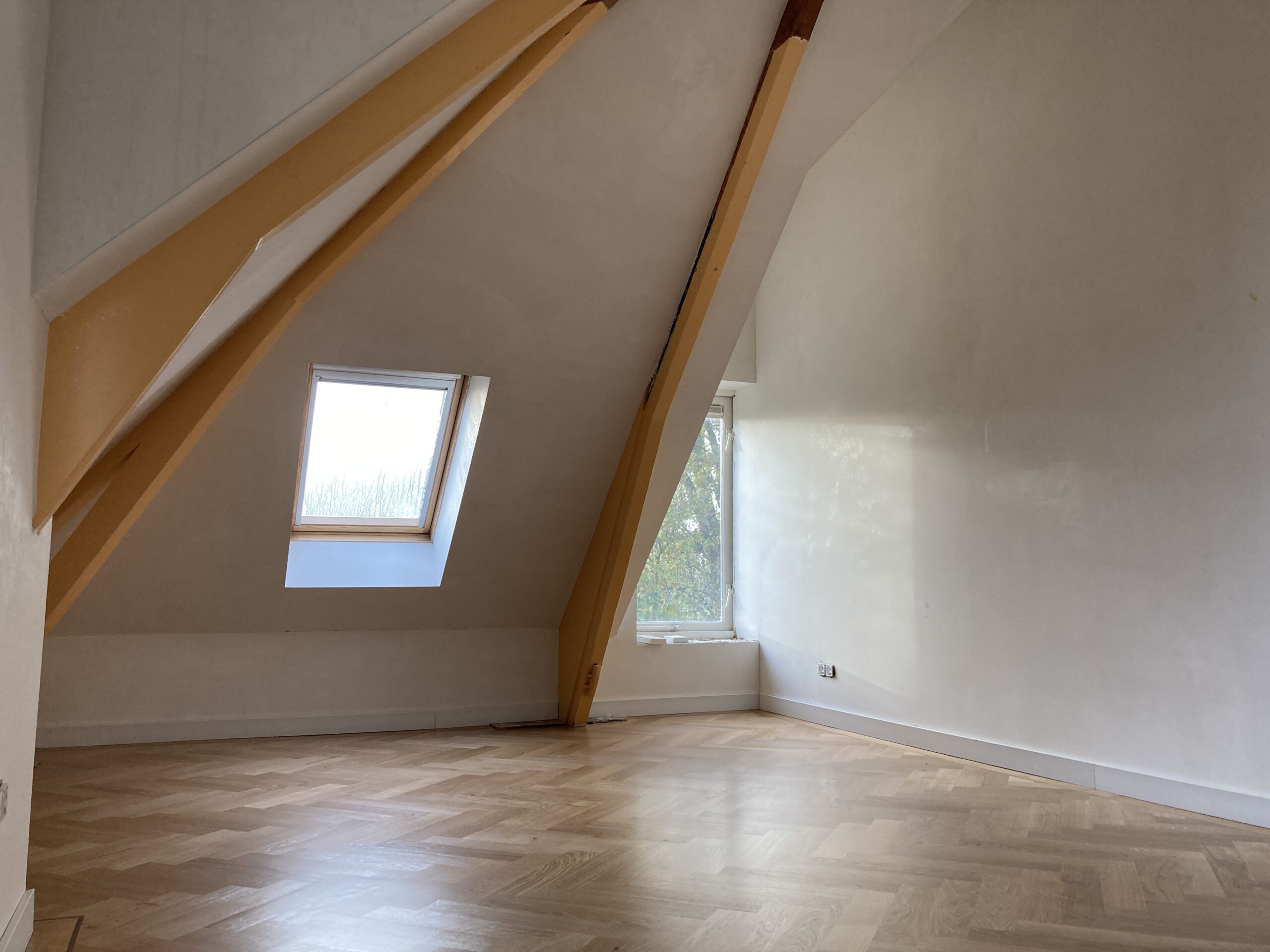 Houten parketvloer en natuurstenen vloer in een gerenoveerde woning.