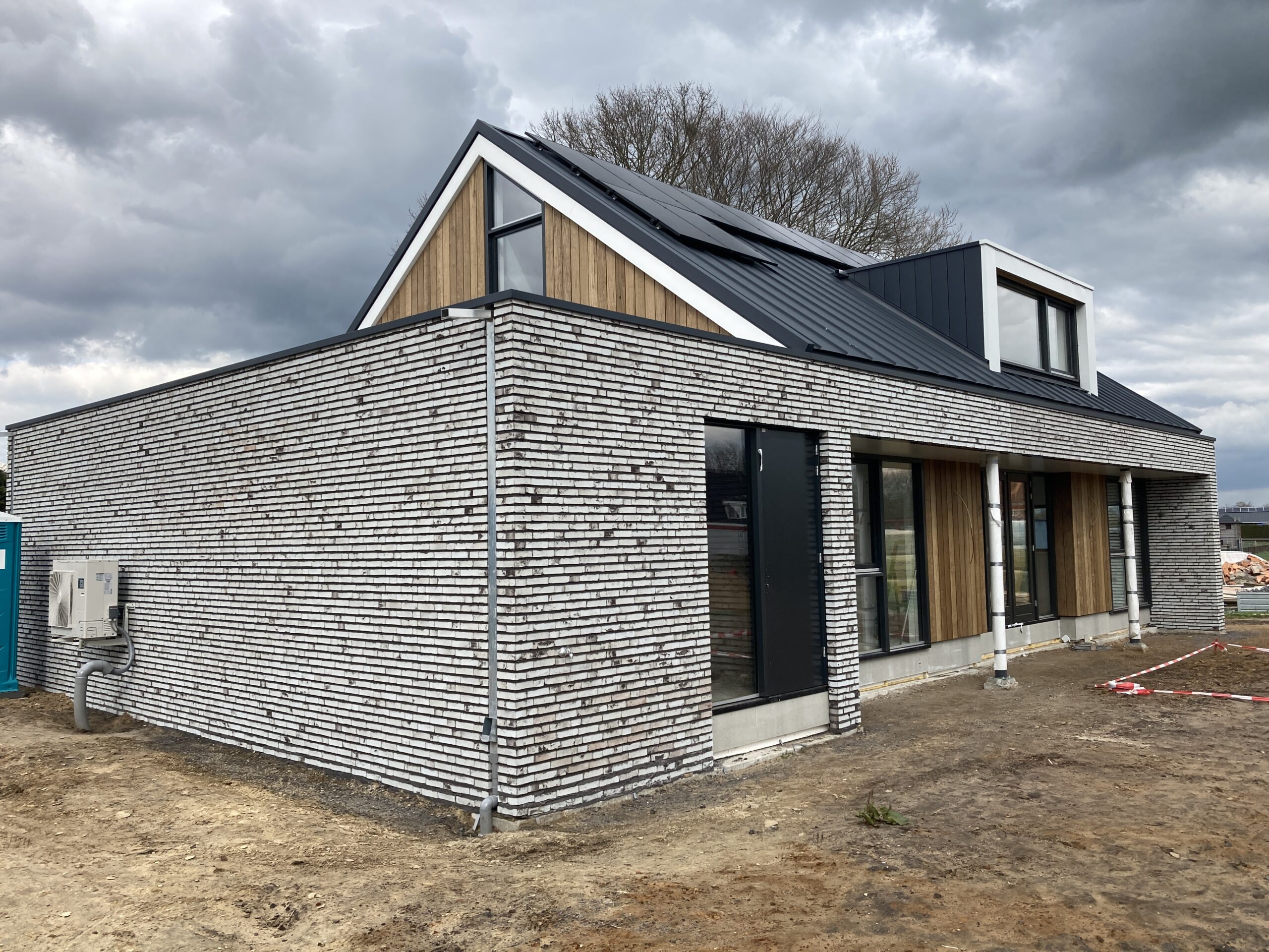 Moderne vrijstaande woning in het buitengebied van Heerde met houten gevelafwerking.