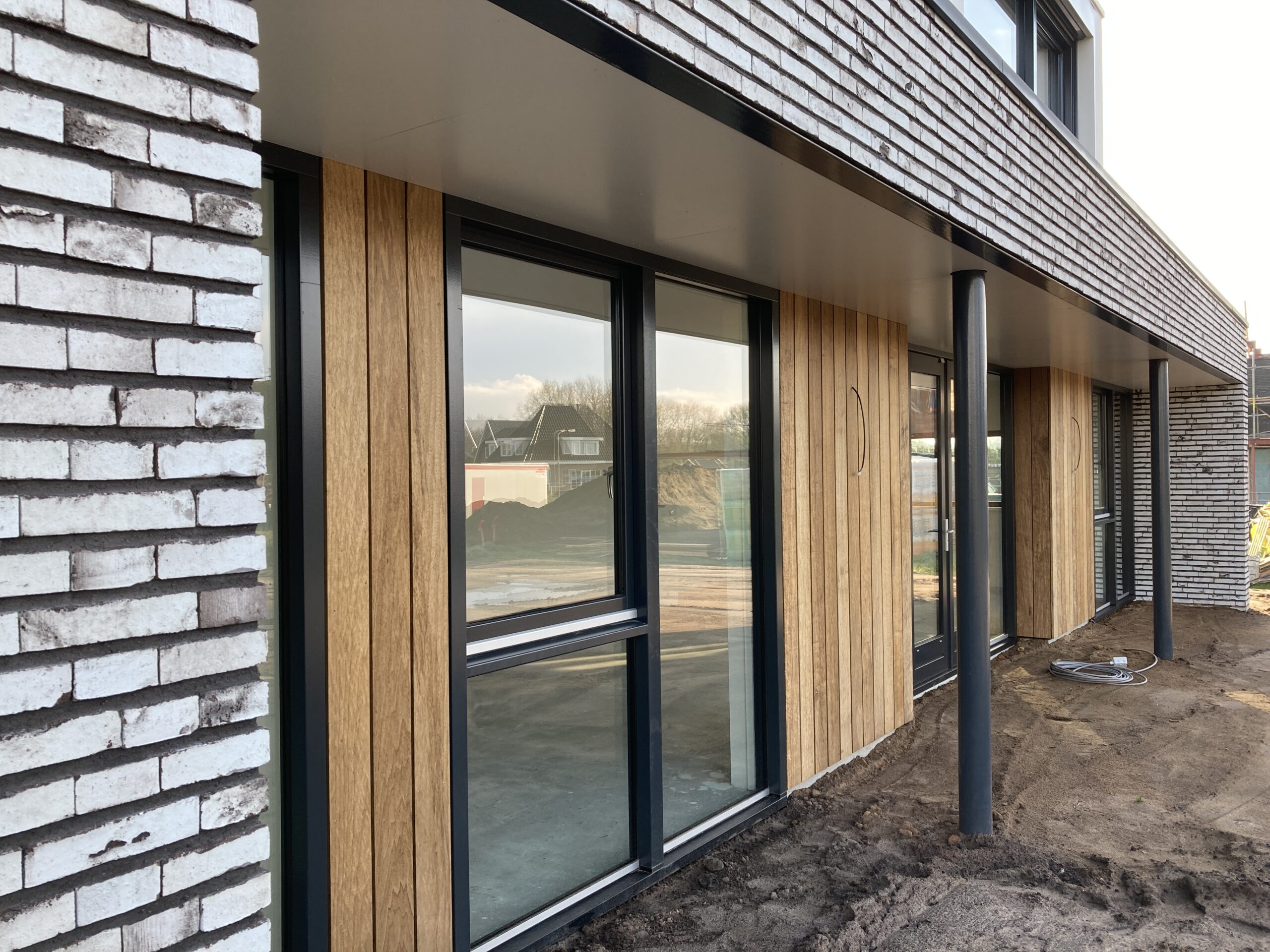 Combinatie van houten betimmering en traditioneel metselwerk bij woning in Heerde.