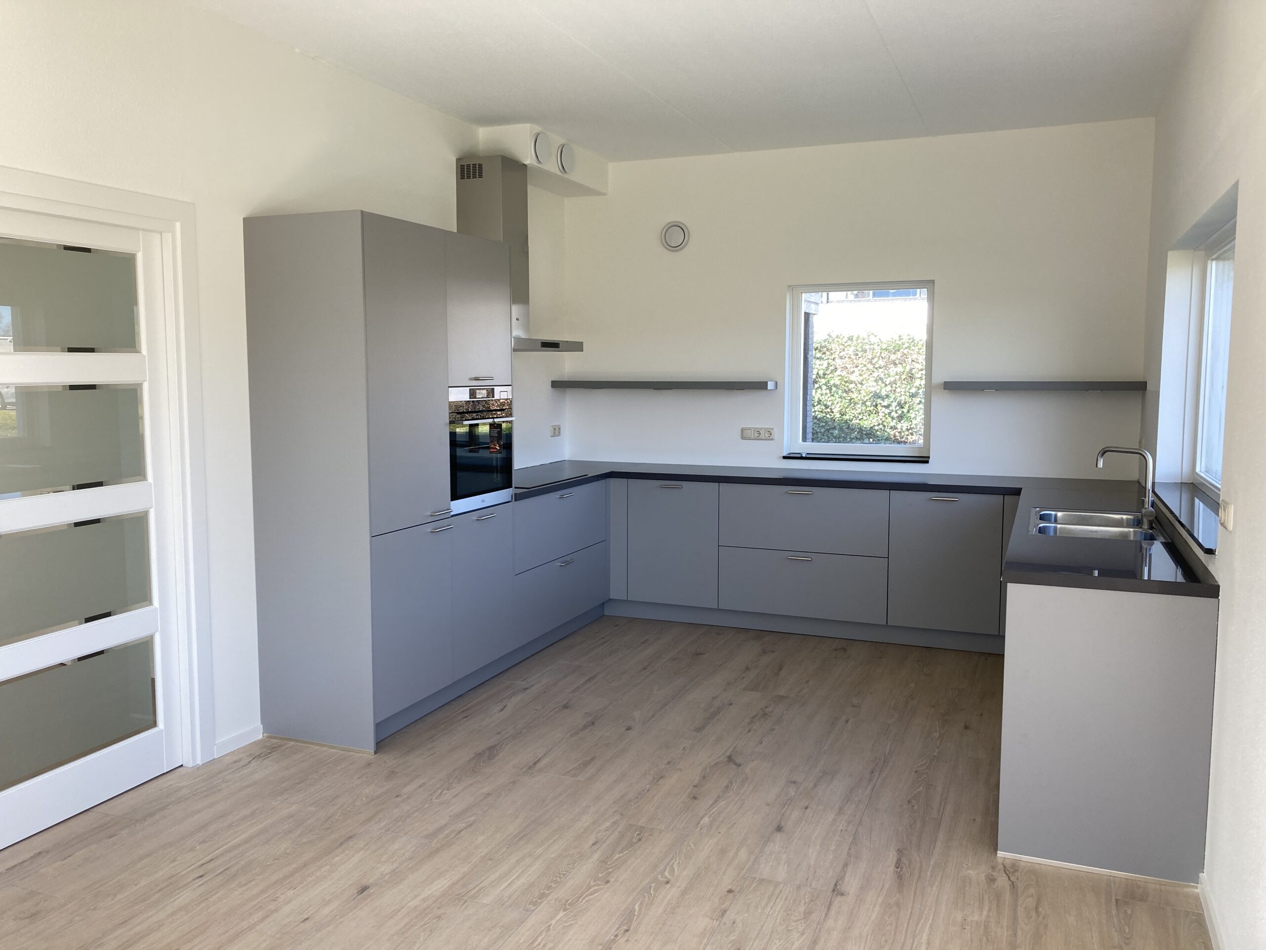 Nieuwe open keuken in gerenoveerde woning in Deventer met moderne apparatuur en veel lichtinval.