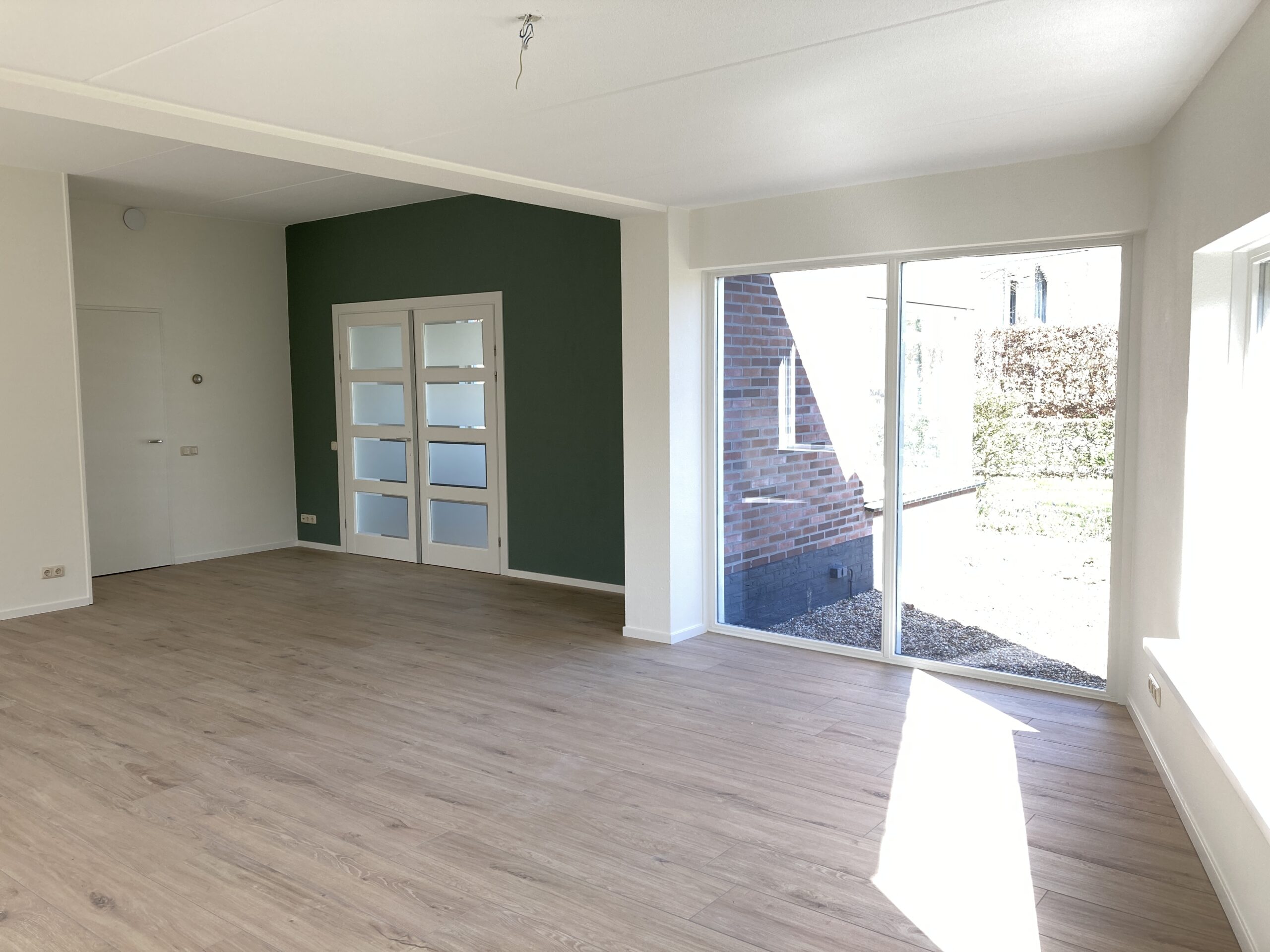 Woonkamer met vloerverwarming en keramische parketvloer in gerenoveerde woning in Deventer.