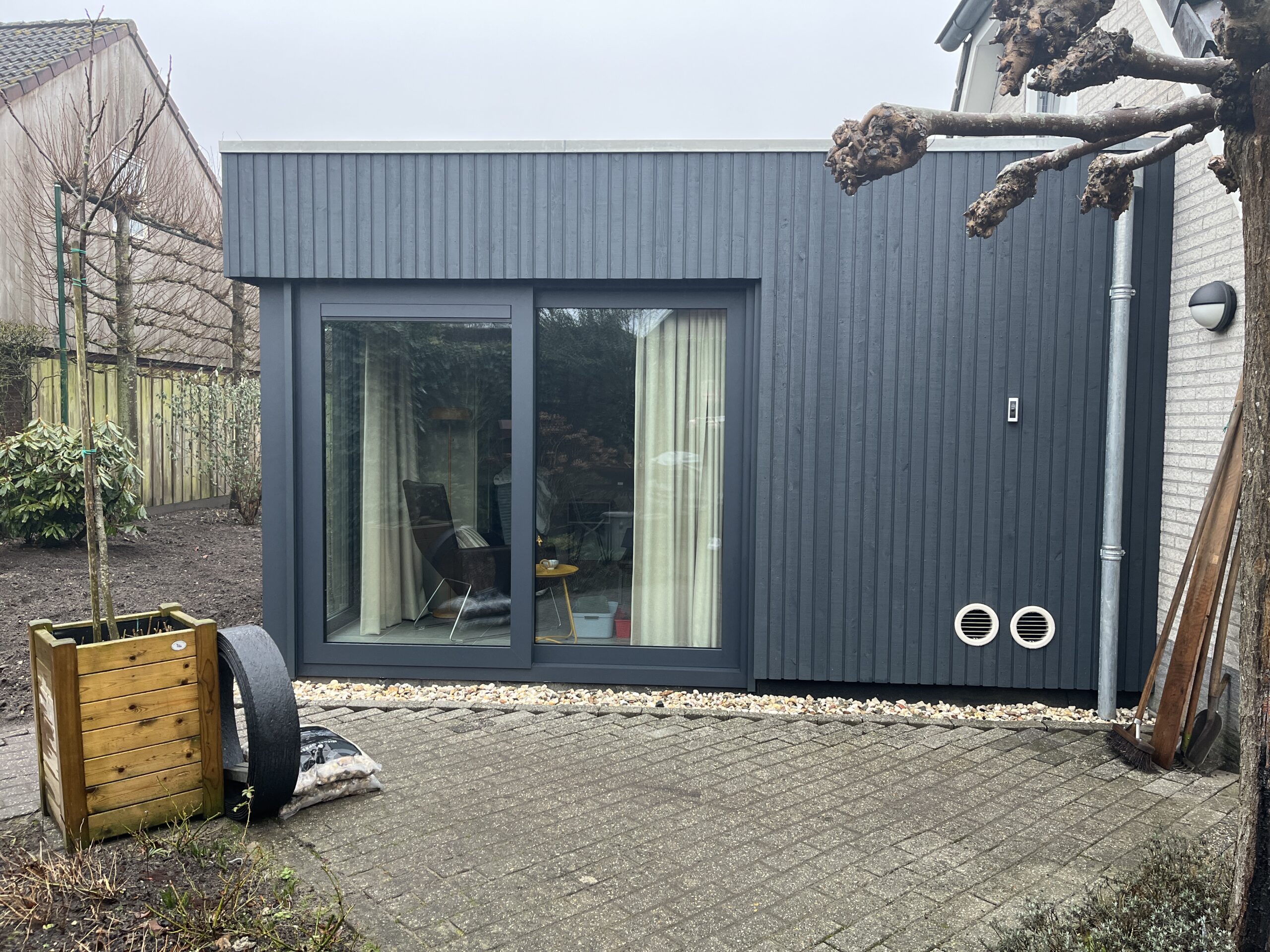 Grote glazen pui met uitzicht op de tuin in de aanbouw.